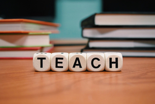 Das Wort "Teach" auf Würfeln